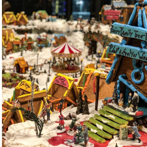 a gingerbread village with people and a carousel