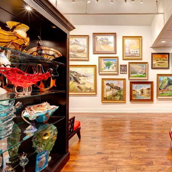 a room with a glass shelf and art on the wall