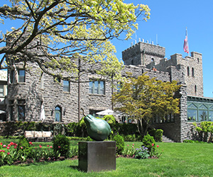 a stone building with a large pear statue in front of it