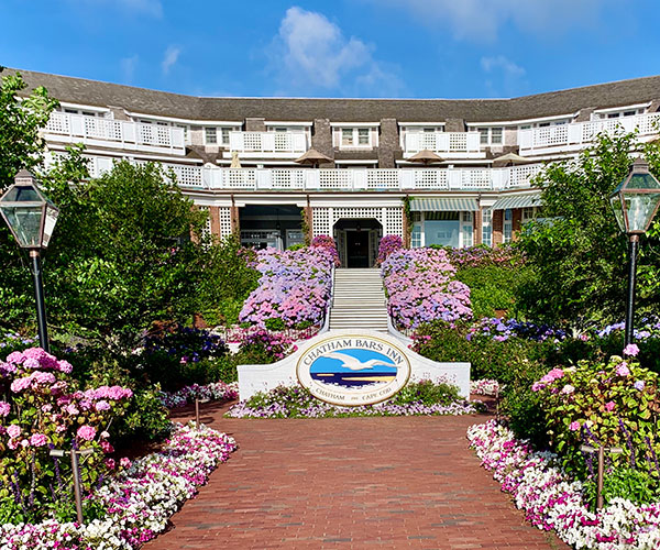 a building with a sign and flowers