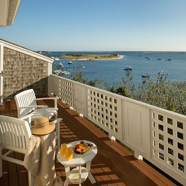 a deck with a table and chairs and a table with fruit on it