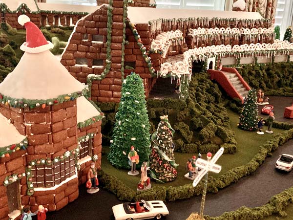 a gingerbread house with trees and a car