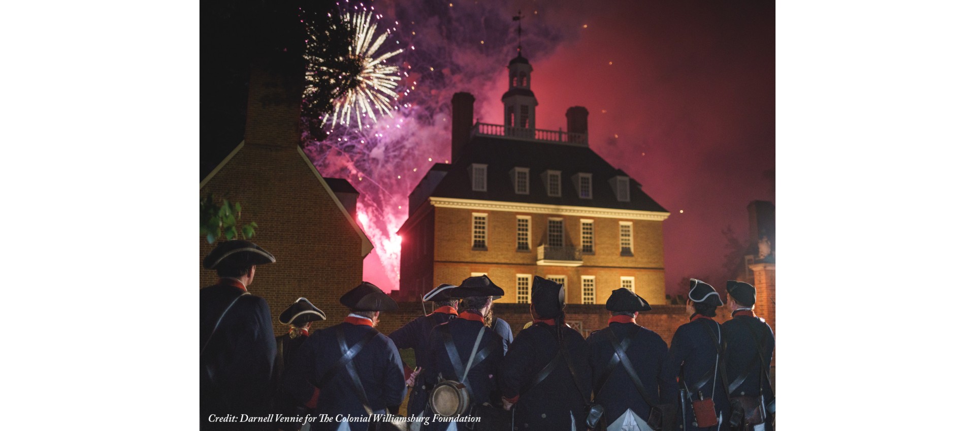 a group of people in uniform looking at fireworks