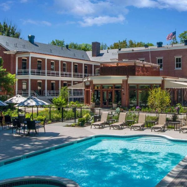 a pool with chairs and a building in the background