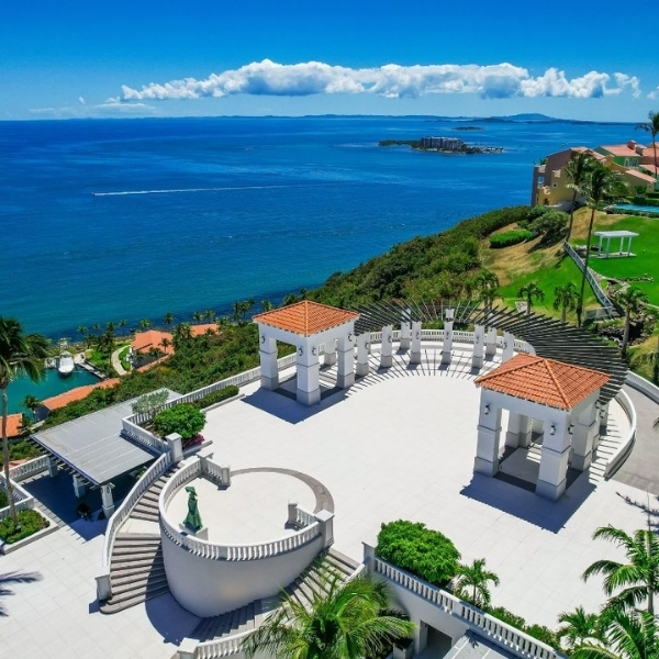 a large white building with a staircase and a body of water