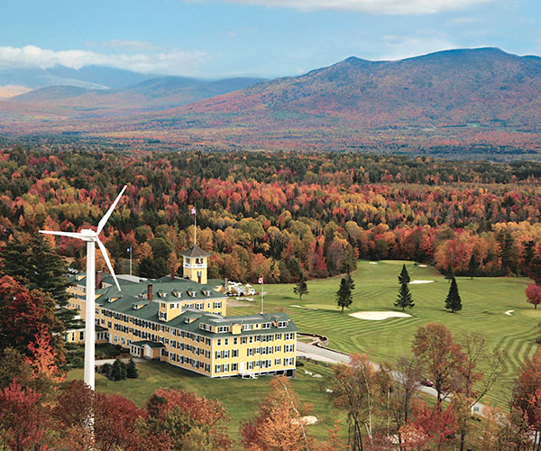 a large building with a golf course and trees in the background