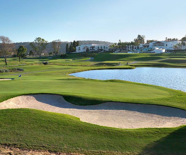 a golf course with a lake and a building