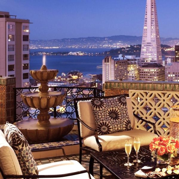 a patio with a fountain and a city view