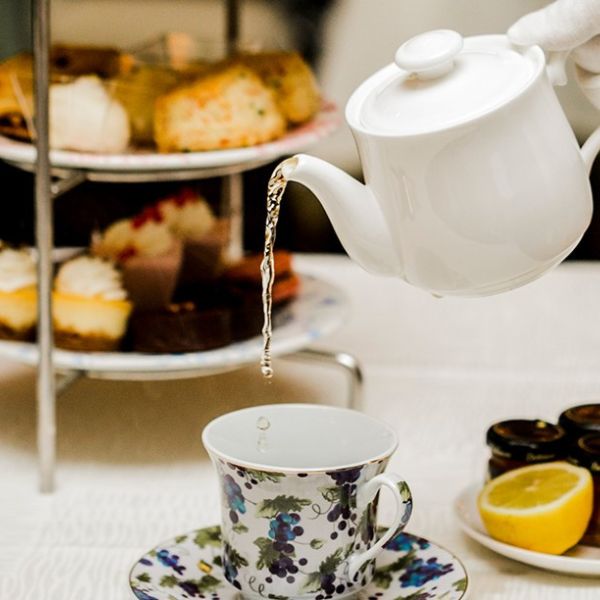 a person pouring water into a tea cup