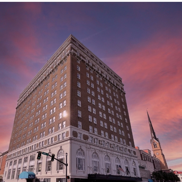 a building with a steeple and a pink sky