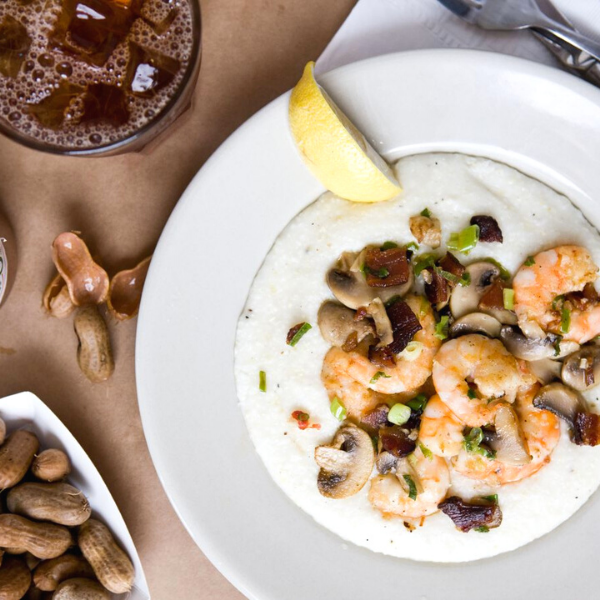 a plate of food with a lemon wedge and peanuts