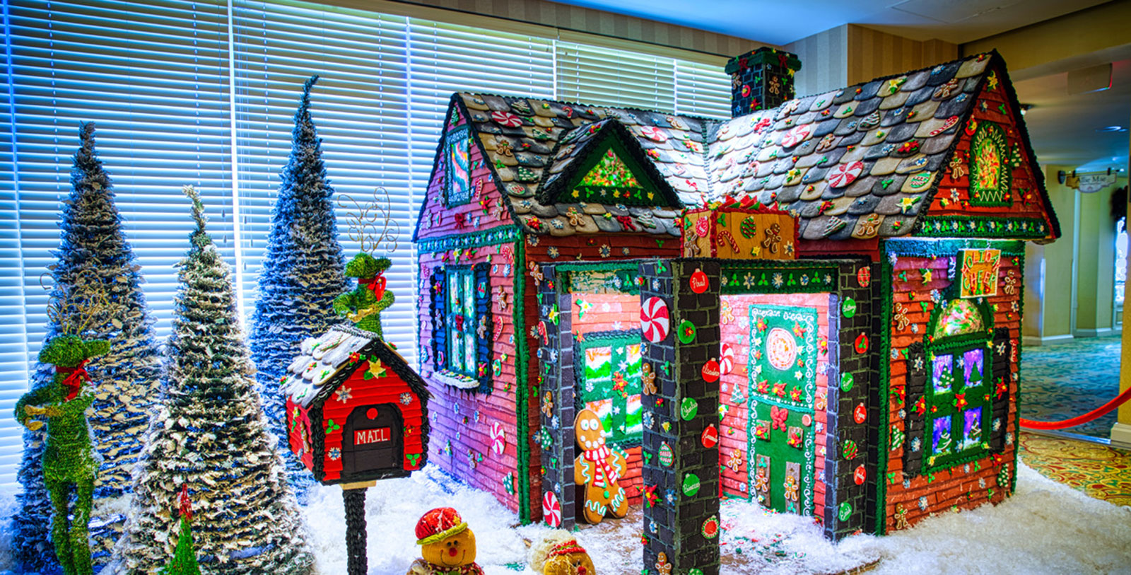 a gingerbread house with a mailbox and trees