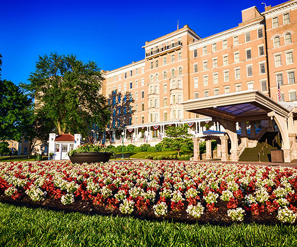 a large building with a lawn and flowers