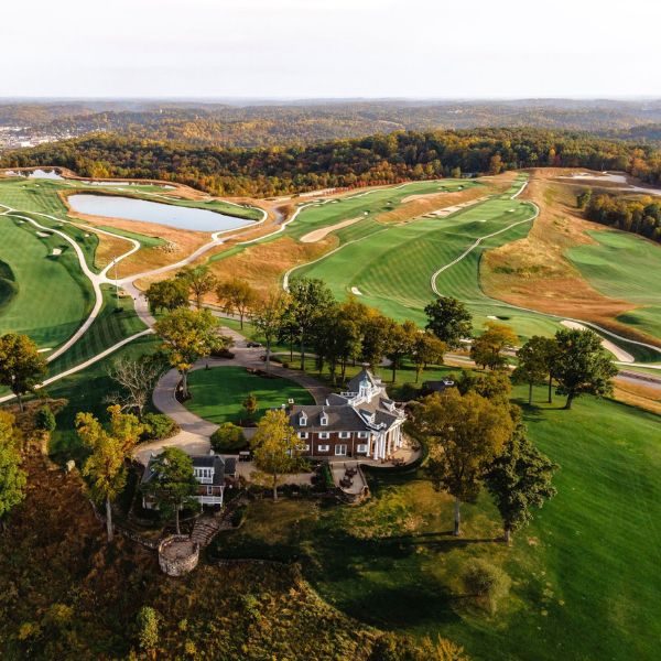 a large golf course with a house and trees