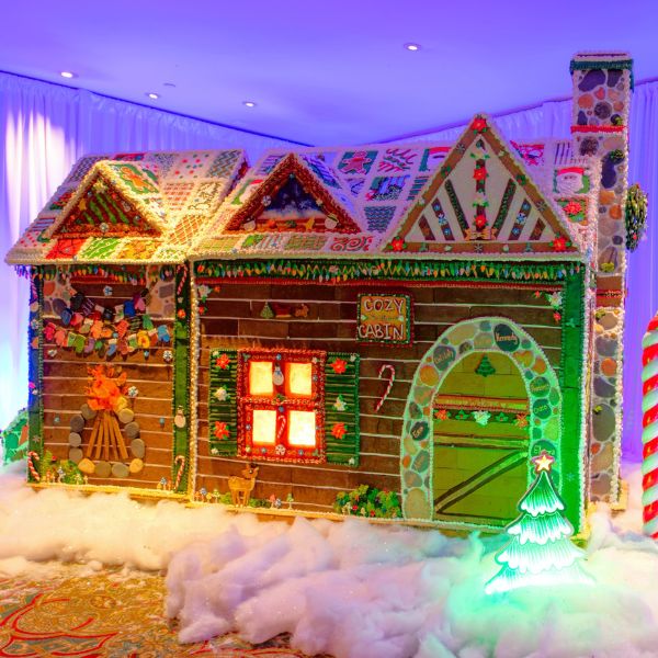 a gingerbread house with lights and a candy cane