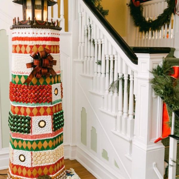 a decorated christmas tree in front of a staircase