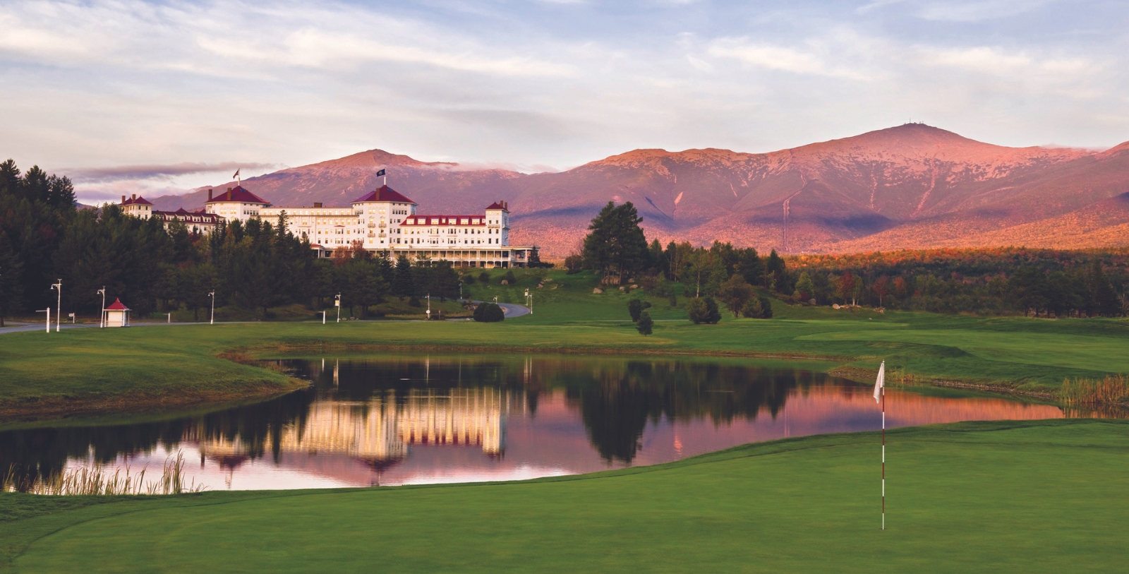 a golf course with a large building and a lake