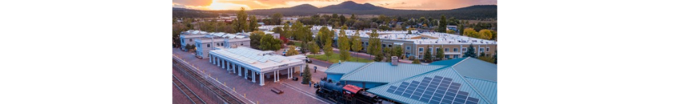 a train station with trees and buildings