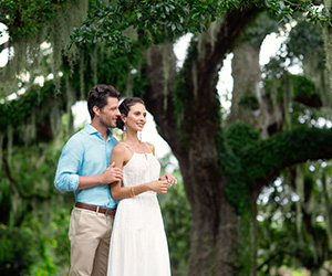 a man and woman standing under a tree