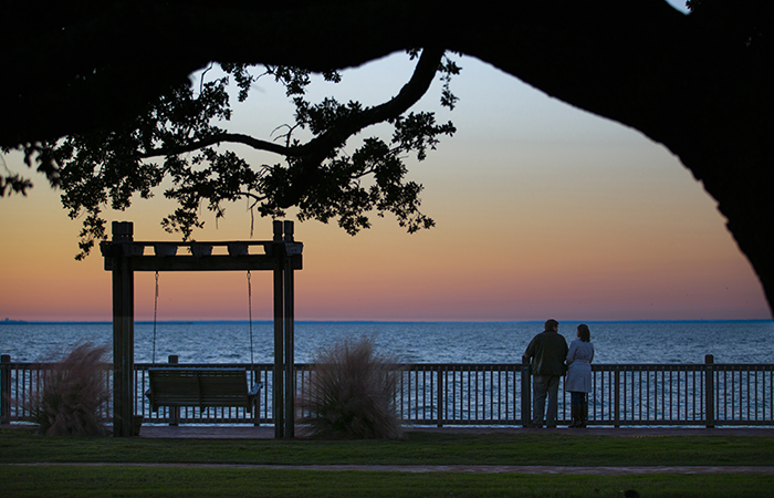 a couple standing on a deck overlooking a body of water
