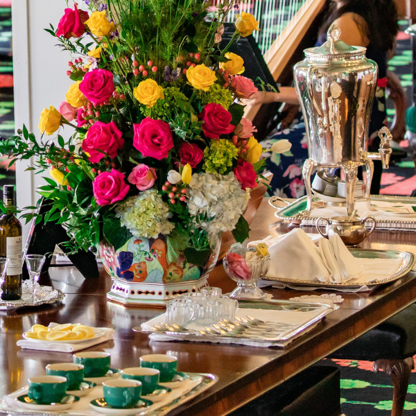 a table with a vase of flowers and tea cups