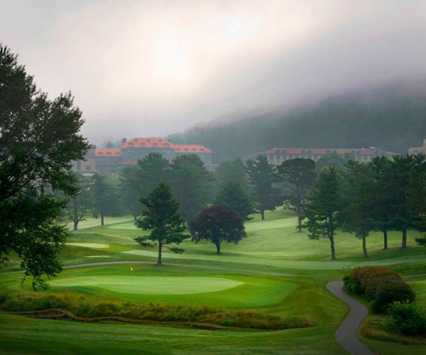 a golf course with trees and a path