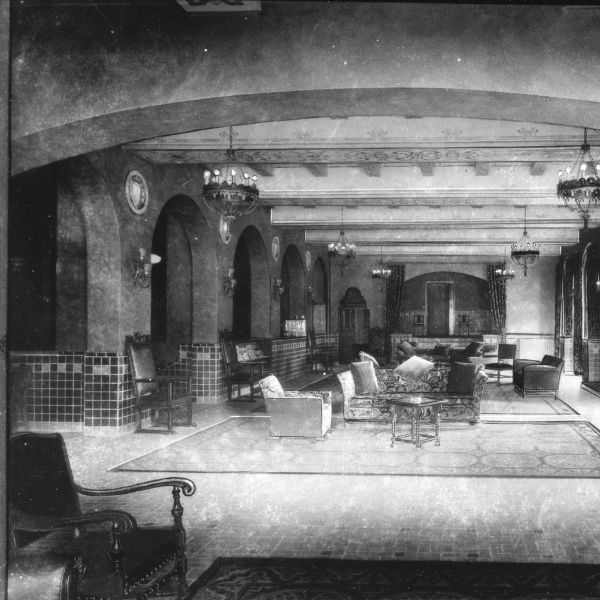 a black and white photo of a room with a couch and chairs