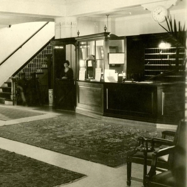 a woman standing behind a counter in a lobby