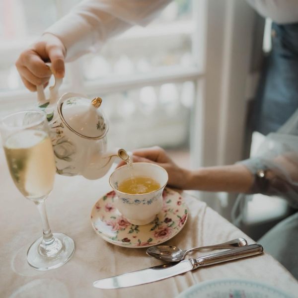 a person pouring tea into a glass