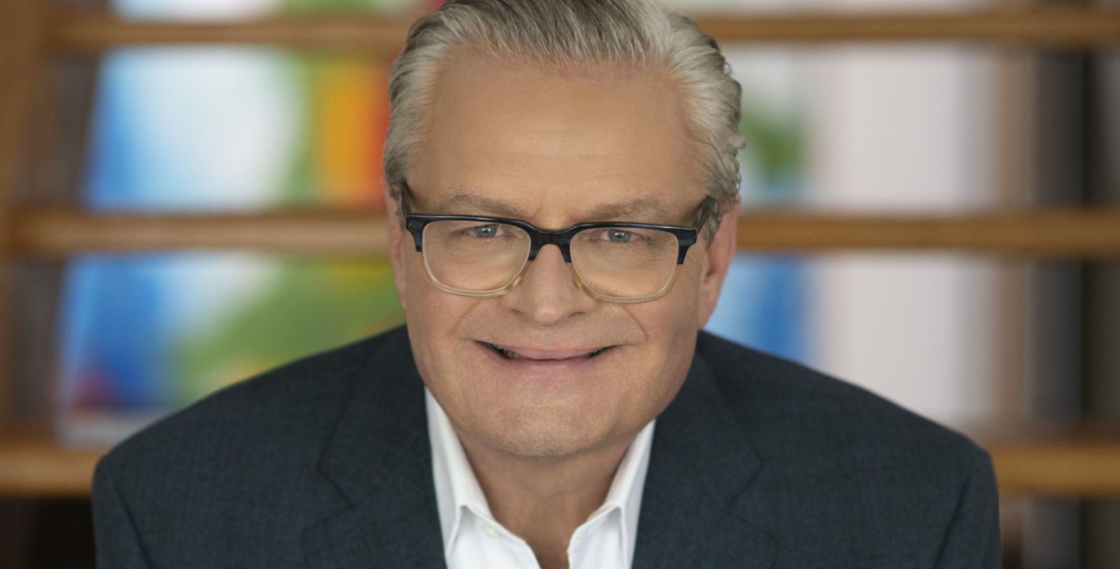 a man wearing glasses and a suit