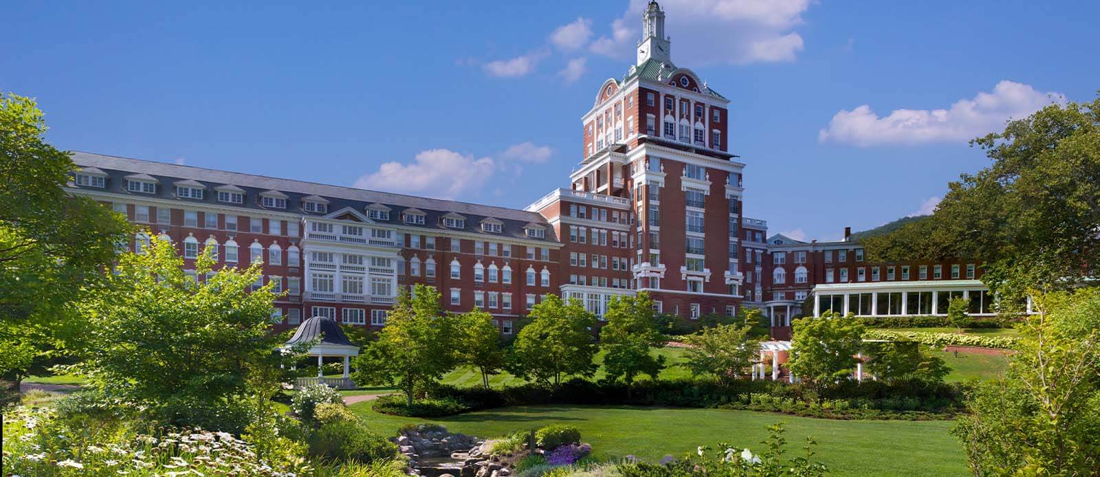a large building with a lawn and trees with The Homestead in the background 2