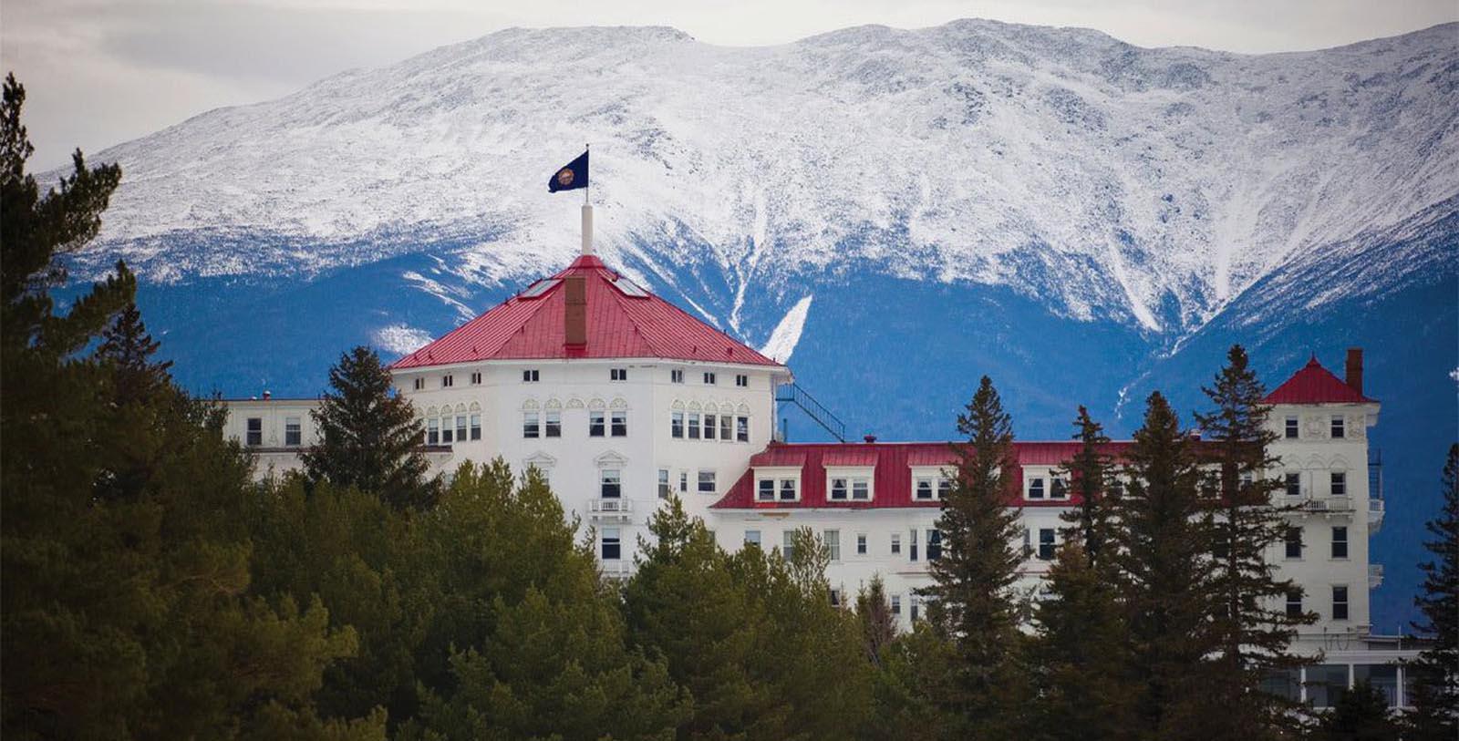 a white building with a red roof and a flag on top 6