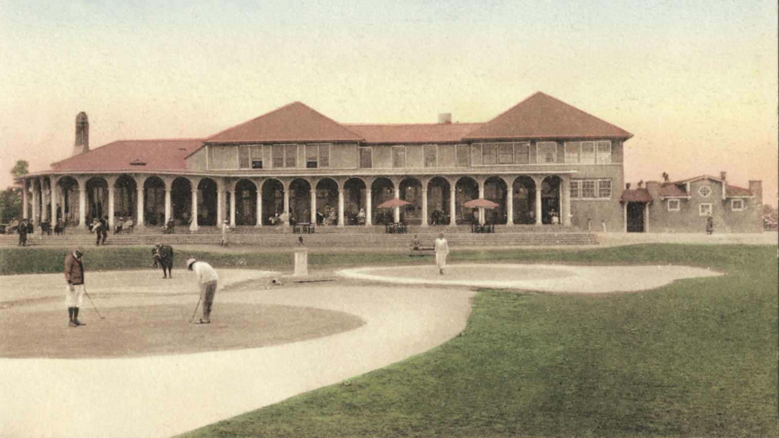 a building with columns and people playing golf