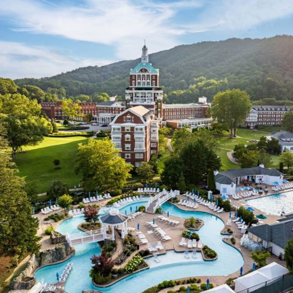 a pool in a resort with The Homestead in the background