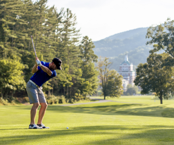 a man swinging a golf club on a golf course