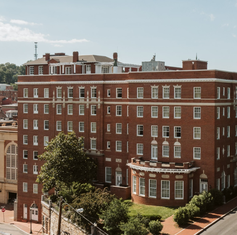 a large brick building with trees and a street