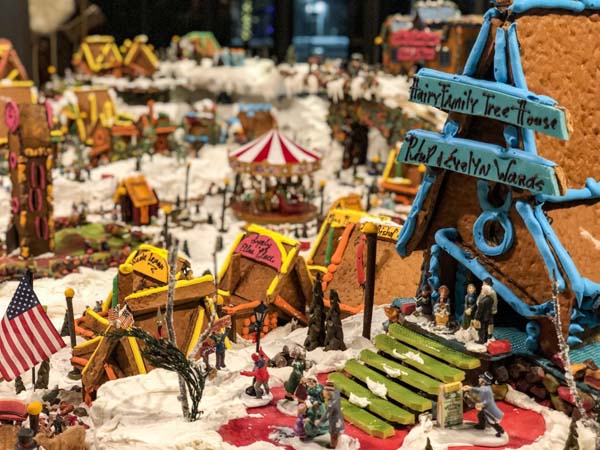 a gingerbread village with people and snow