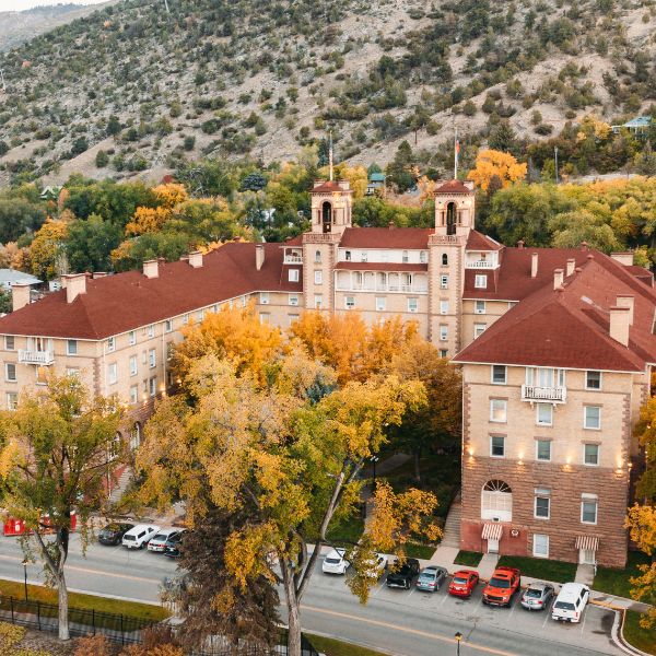 a building with trees and a hill in the background