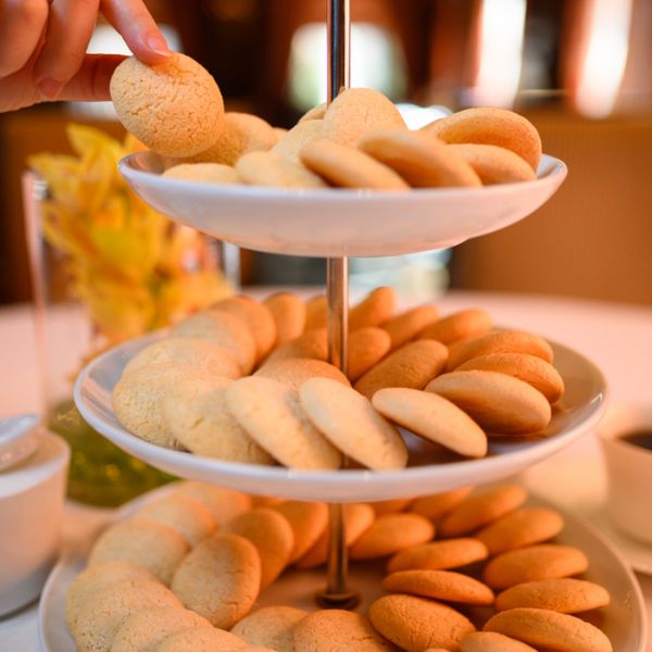 a hand reaching over a stack of cookies