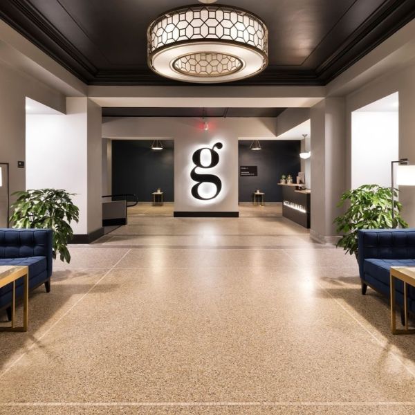 a lobby with blue couches and a lamp
