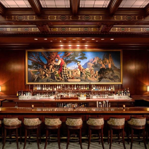 a bar with many bottles and a painting on the wall