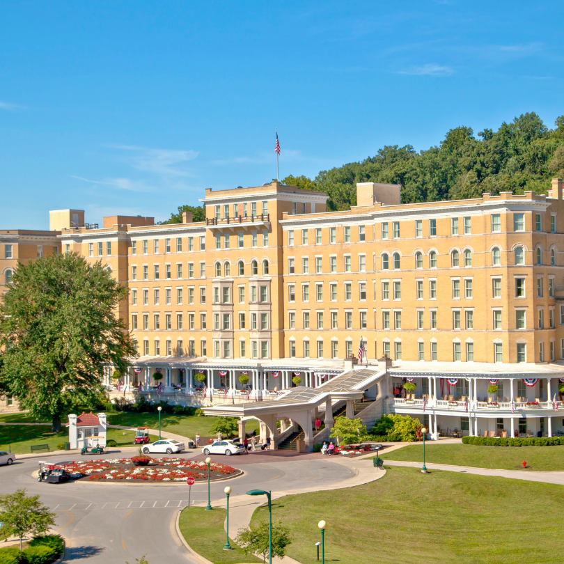 a large building with a parking lot and trees