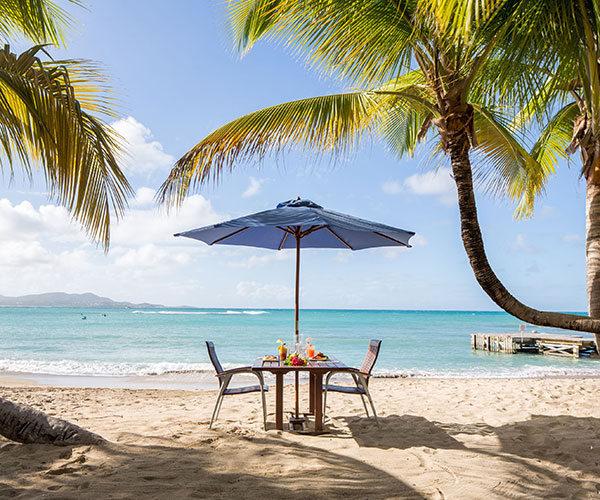 a table and chairs on a beach