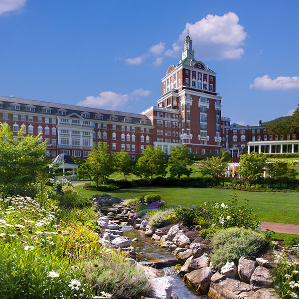 a large building with a stream running through it with The Homestead in the background
