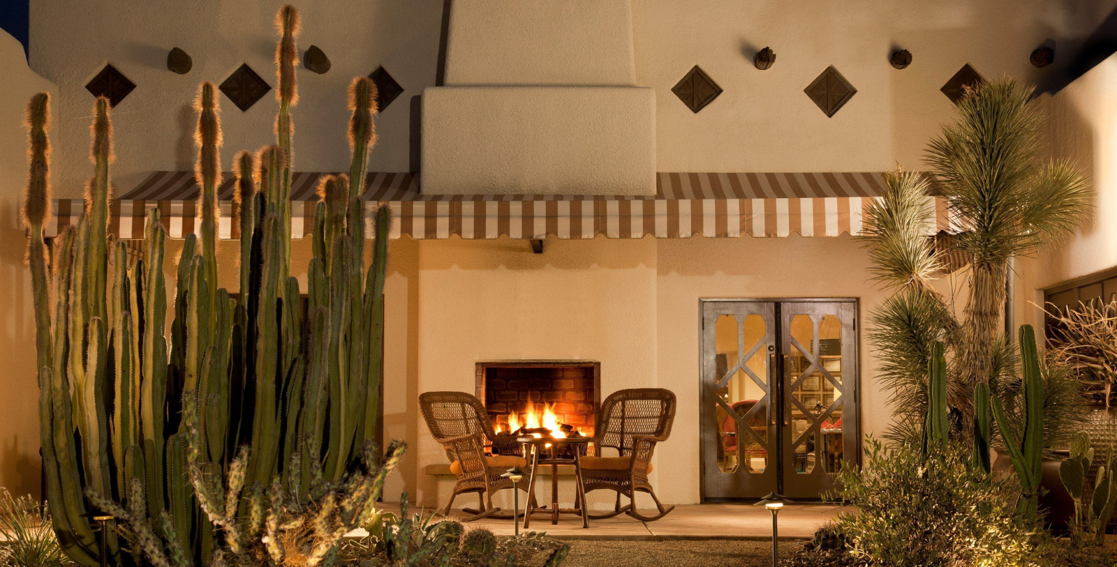 a fire place with chairs and a table in front of a building
