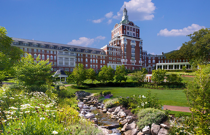 a large building with a stream running through it with The Homestead in the background