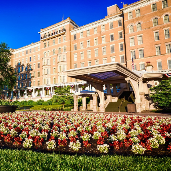 a large building with a flower bed and a walkway
