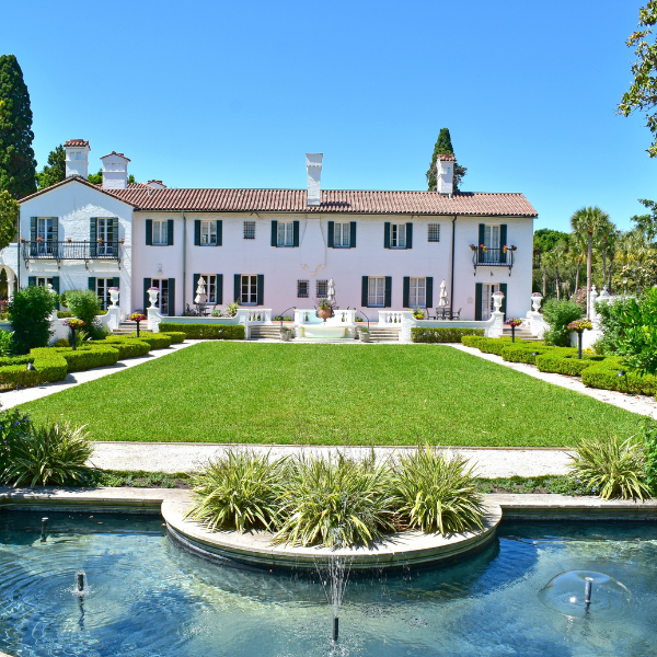 a large white house with a fountain in front of it