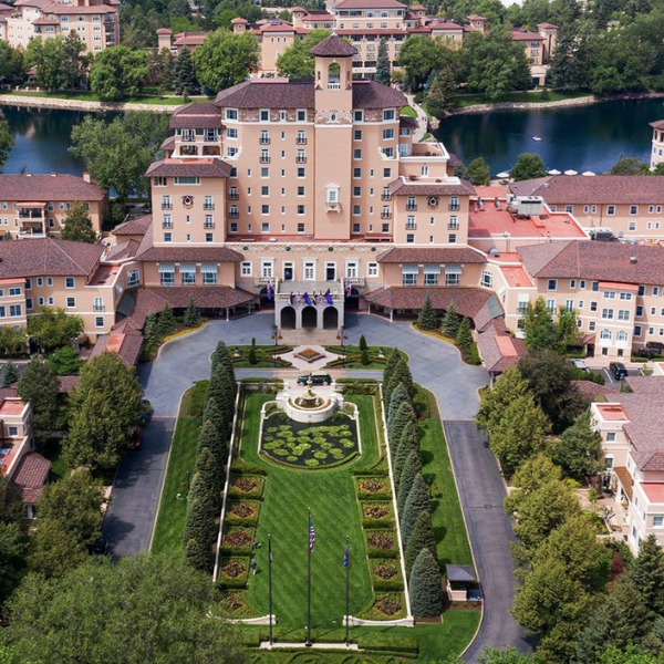 a large building with a garden and a pond