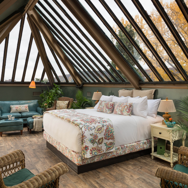 a room with a bed and chairs